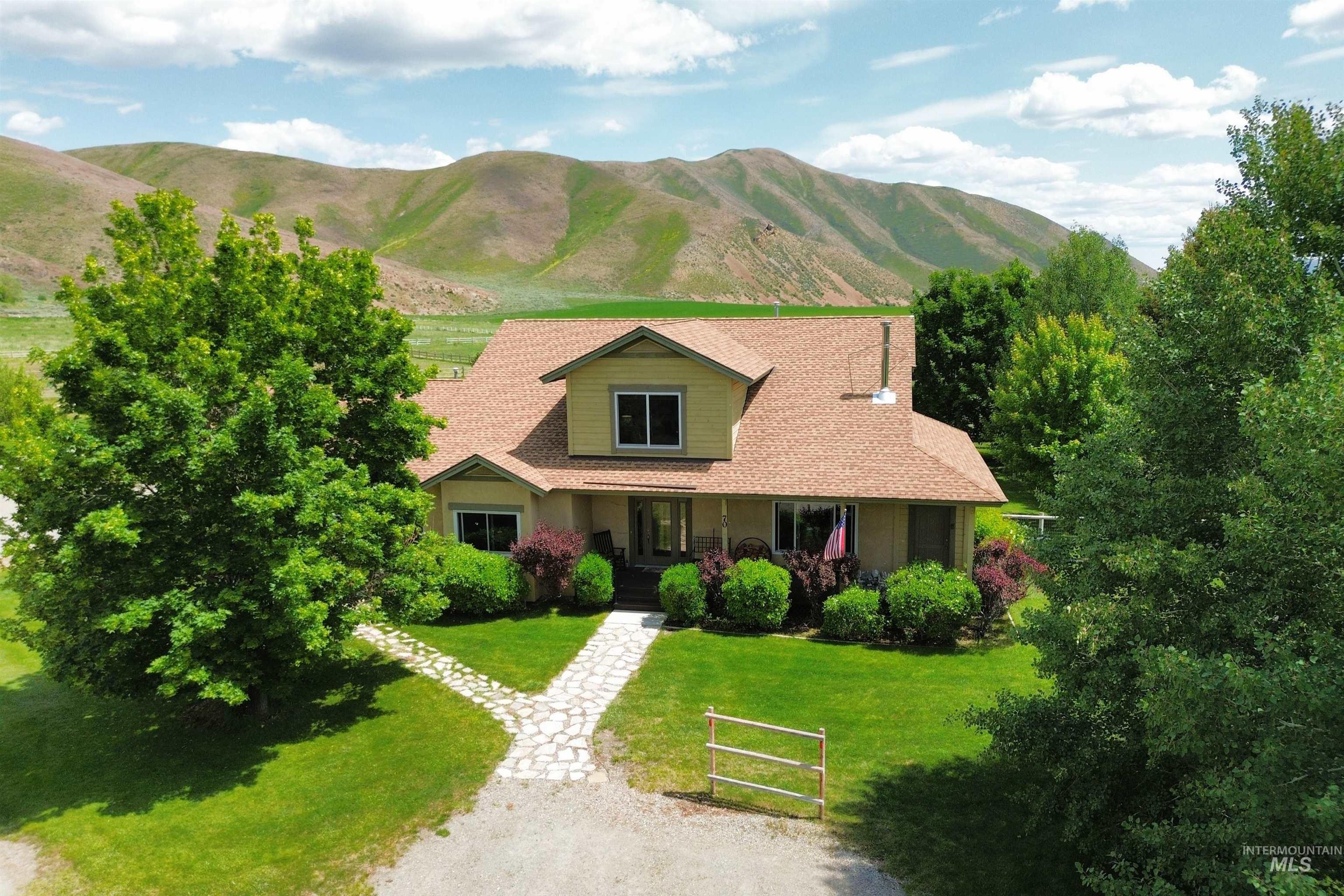 View of front of property with covered porch, a front yard, a mountain view, and roof with shingles