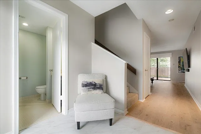 a view of a hallway with bathroom and wooden floor