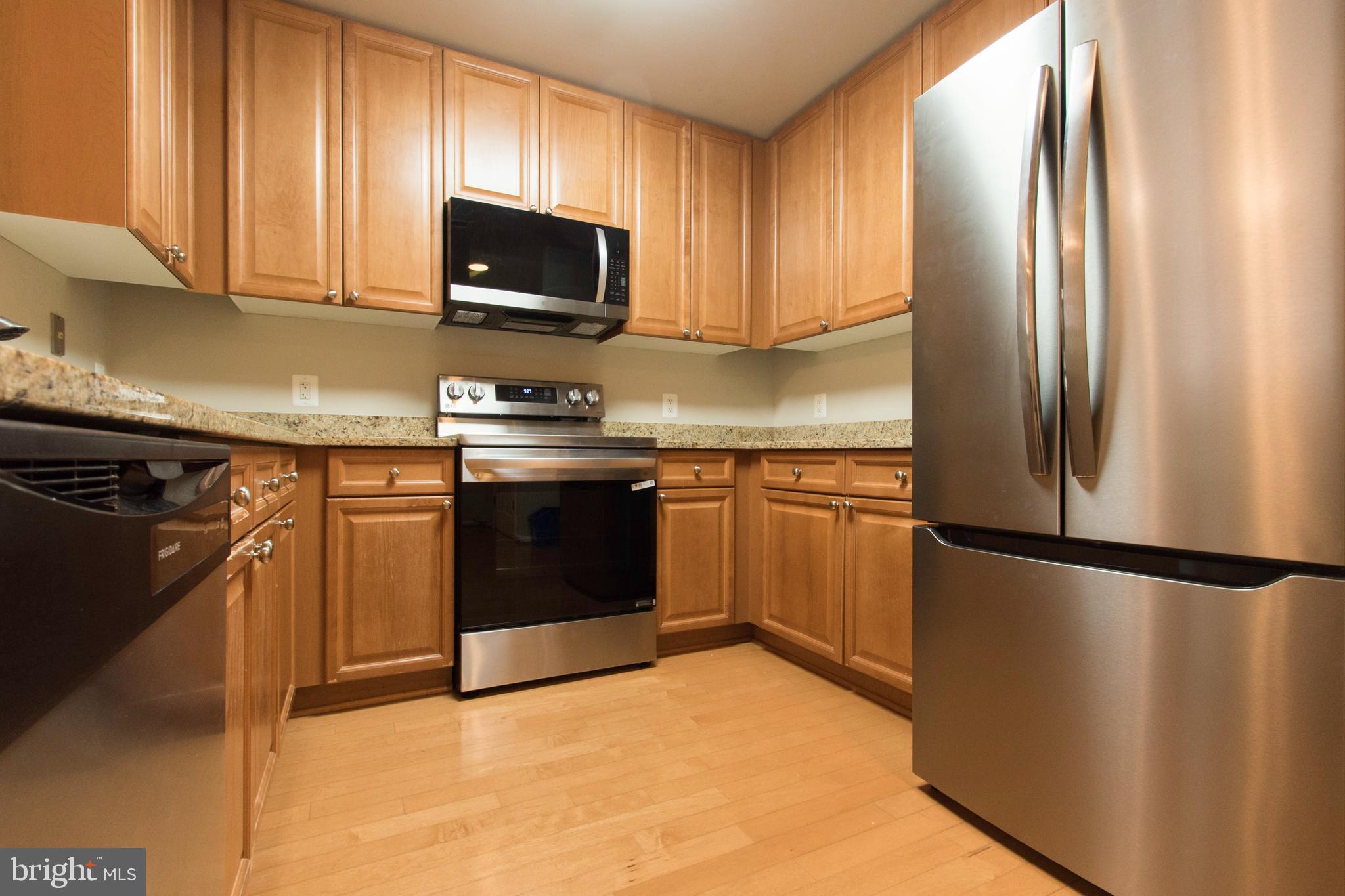 11700 Old Georgetown Road, Unit 807 North Bethesda, MD 20852 - Photo 11 of 37 a kitchen with stainless steel appliances granite countertop a refrigerator stove top oven a sink and dishwasher