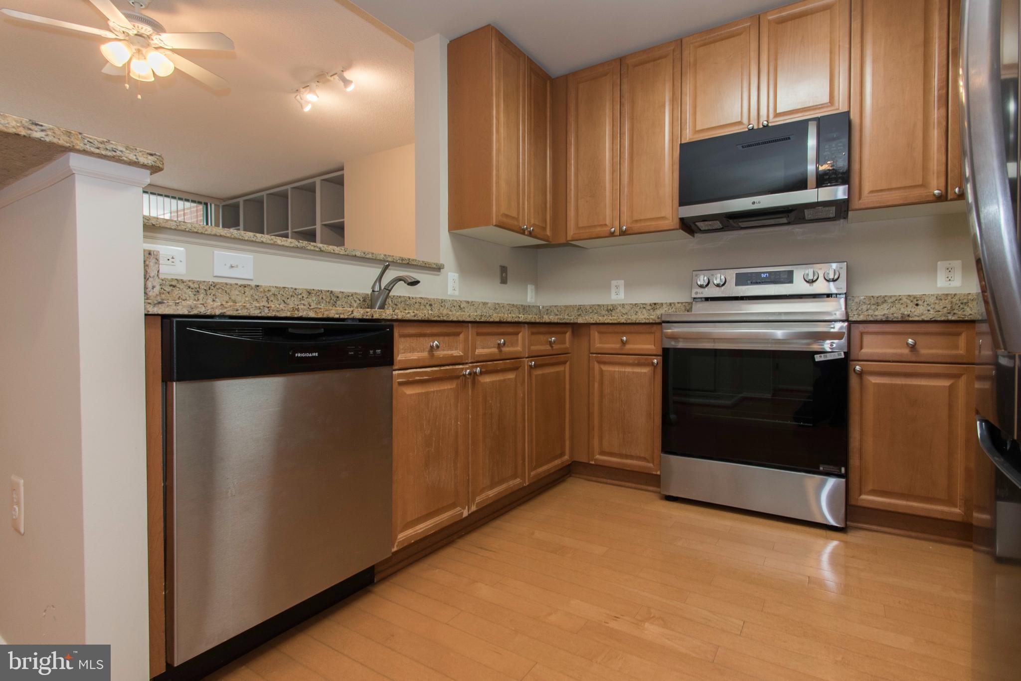 11700 Old Georgetown Road, Unit 807 North Bethesda, MD 20852 - Photo 12 of 37 a kitchen with granite countertop a stove top oven sink and cabinets