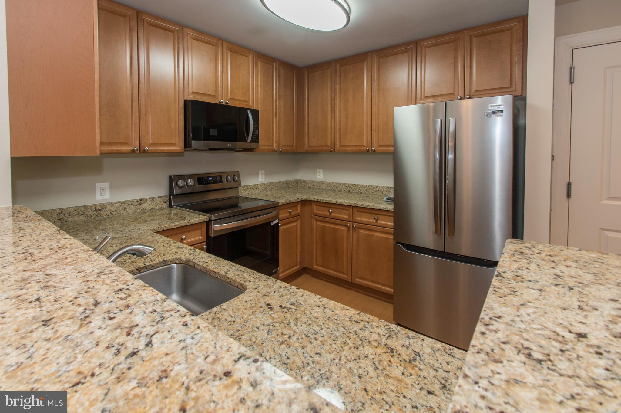 11700 Old Georgetown Road, Unit 807 North Bethesda, MD 20852 - Photo 9 of 37 a kitchen with granite countertop wooden cabinets and stainless steel appliances
