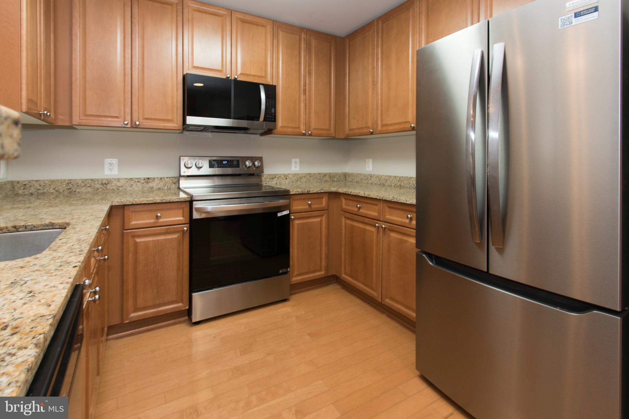 11700 Old Georgetown Road, Unit 807 North Bethesda, MD 20852 - Photo 10 of 37 a kitchen with stainless steel appliances granite countertop a refrigerator stove a sink and a microwave