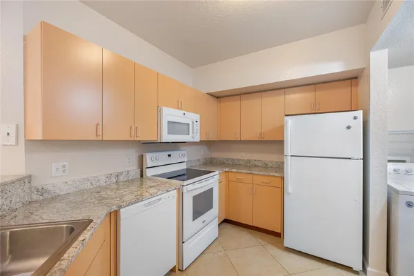 a kitchen with cabinets appliances a sink and a counter top space