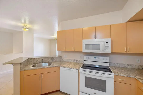 a kitchen with granite countertop a stove sink and cabinets