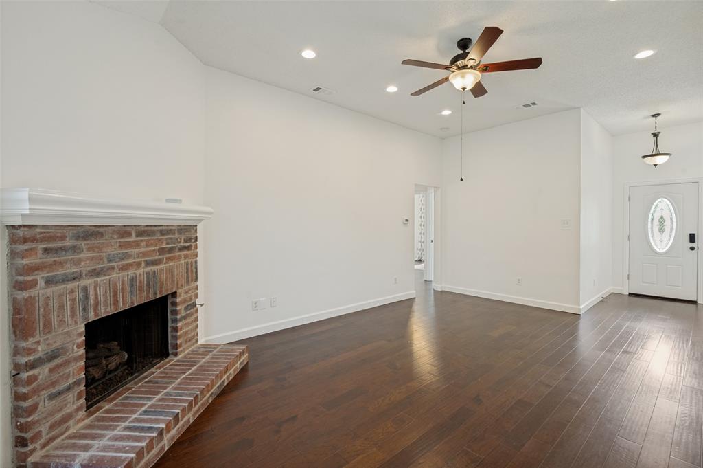 8160 Tower Road Frisco, TX 75035 - Photo 11 of 25 an empty room with wooden floor a fireplace