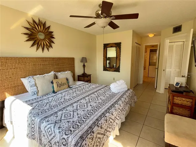 a bedroom with a large bed and a chandelier