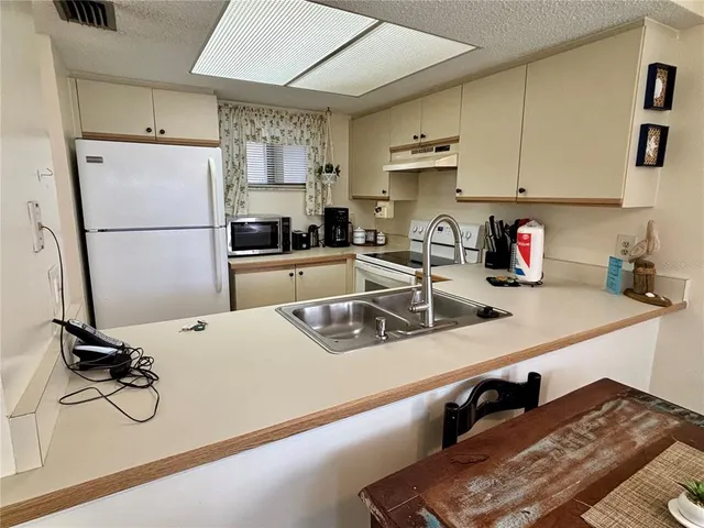 a kitchen with a refrigerator a sink and cabinets
