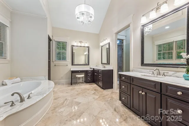 a spacious bathroom with a double vanity sink double mirror and bathtub