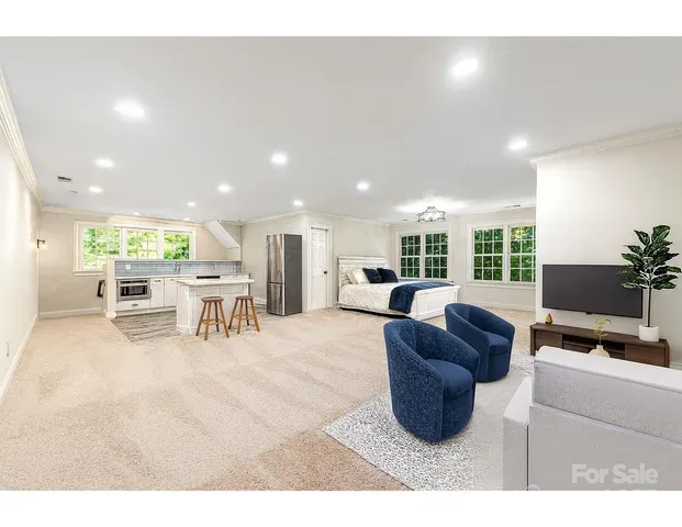 a living room with furniture a flat screen tv and a large window