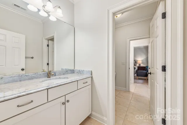 a en suite bathroom with a granite countertop sink a mirror and a vanity