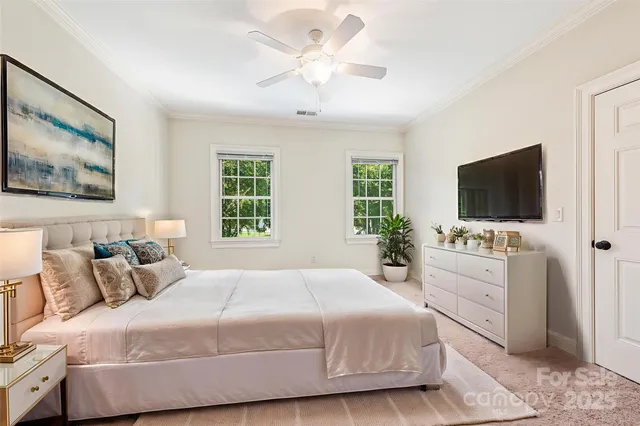 a bedroom with a large bed and a flat tv screen on dresser