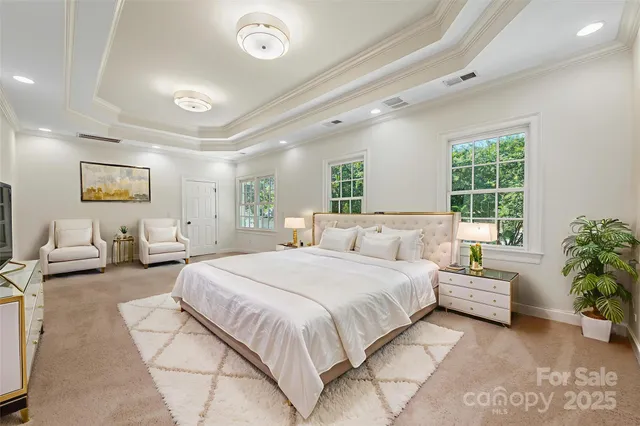 a spacious bedroom with a large bed couch and windows