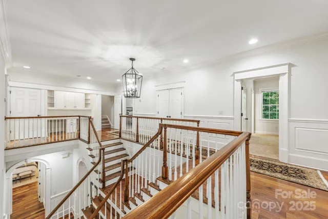 a view of a hallway with wooden floor and staircase