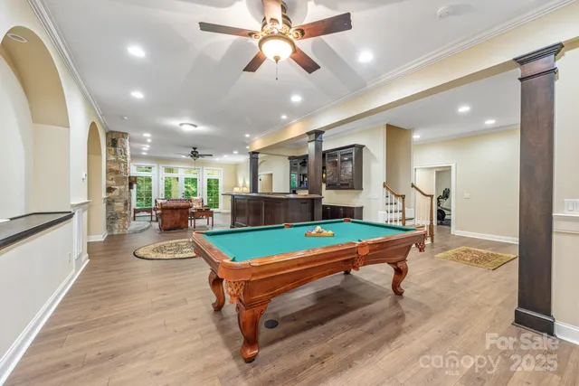 a large kitchen with granite countertop a sink and a white wooden cabinets