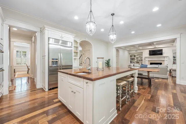 a kitchen with a stove a refrigerator and a view of living room