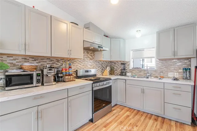 a kitchen with cabinets appliances a sink and a counter top space
