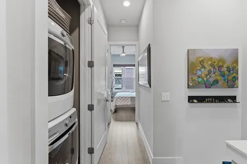 a view of a hallway to rooms and wooden floor