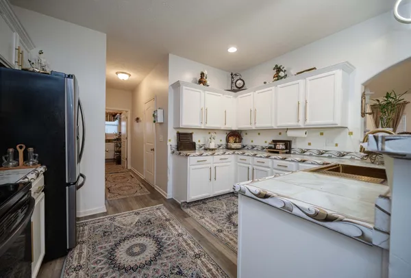 a kitchen with granite countertop a refrigerator stove and sink