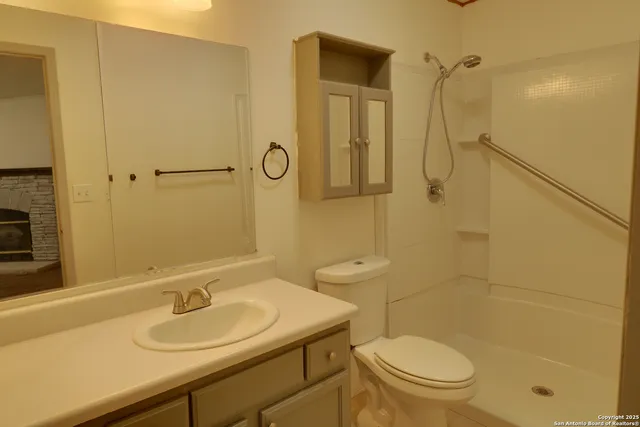 a bathroom with a sink a toilet and shower