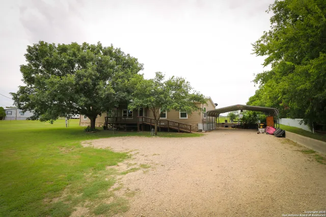 a front view of a house with a garden and trees