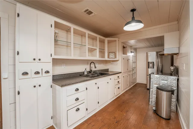 a large kitchen with granite countertop a sink and cabinets