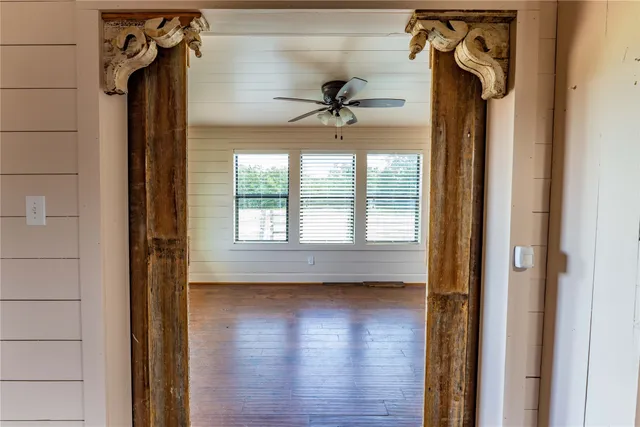 a view of a hallway with a window and wooden floor