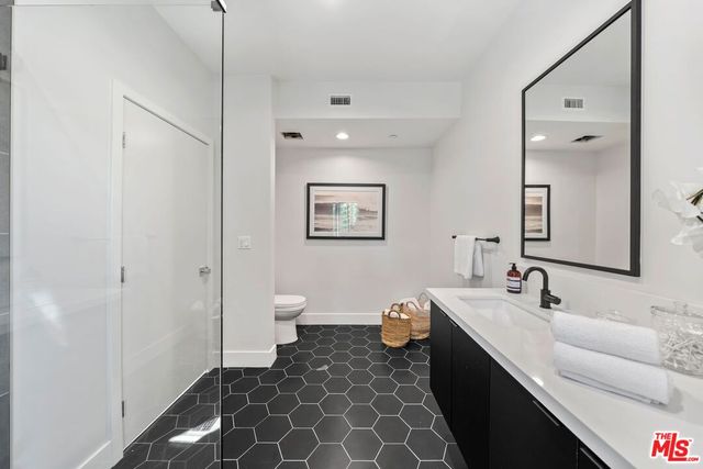 a bathroom with a double vanity sink mirror and toilet