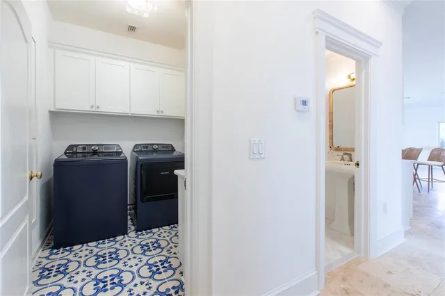 a walk in closet with wooden floor