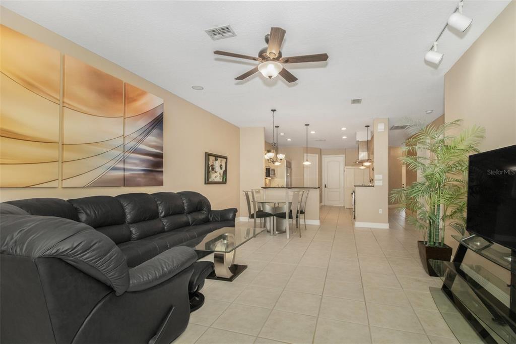 19331 Haskell Place Land O Lakes, FL 34638 - Photo 14 of 34 a living room with furniture and a flat screen tv with kitchen view