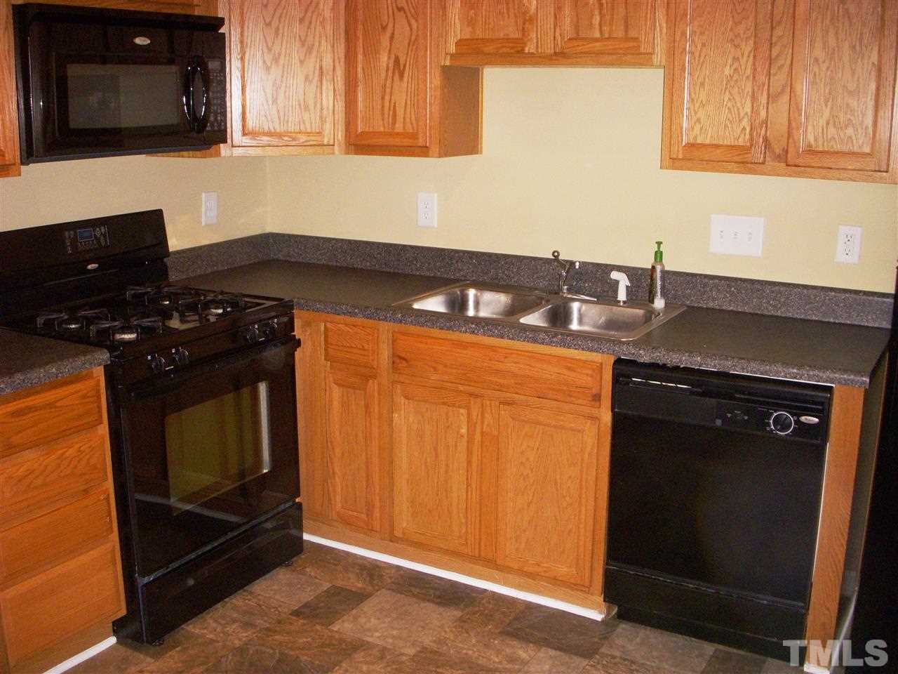 11720 Coppergate Drive, Unit 111 Raleigh, NC 27614 - Photo 3 of 15 a kitchen with granite countertop a stove and a microwave