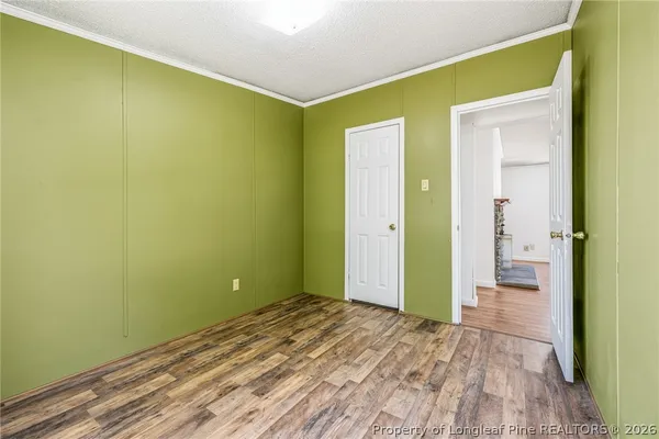 a view of a room with wooden floor and a bathroom