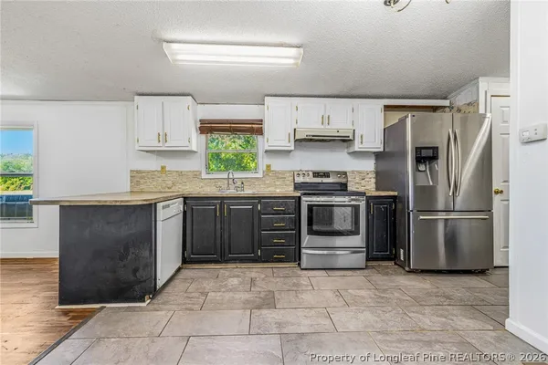 a kitchen with stainless steel appliances a stove a sink and a refrigerator