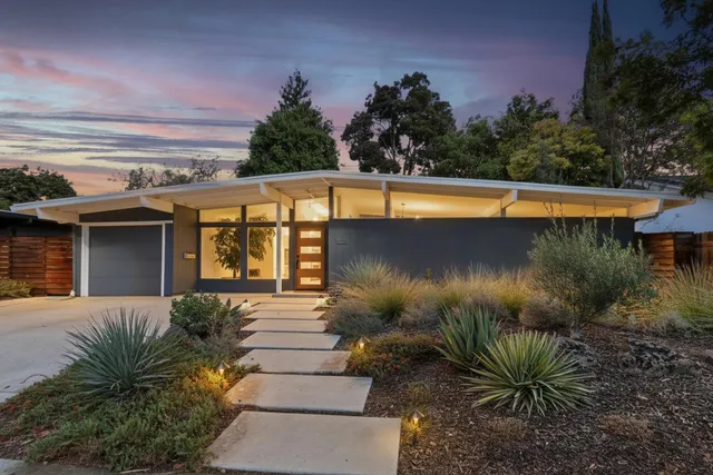 a view of a house with a small yard and plants
