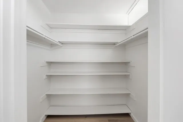 a view of a big room with wooden floor and windows in a room