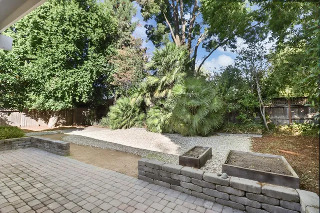 a view of a house with a yard and potted plants