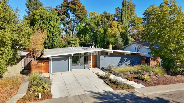 an aerial view of residential houses with outdoor space and trees