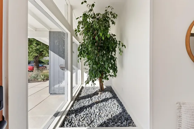 a dining room with furniture and a floor to ceiling window