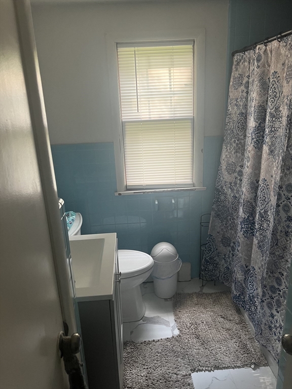 64 Fox Hill Road Springfield, MA 01118 - Photo 7 of 14 a white toilet sitting next to a bathroom sink and vanity