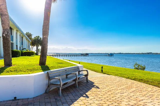 a view of a swimming pool with a bench and lawn chairs
