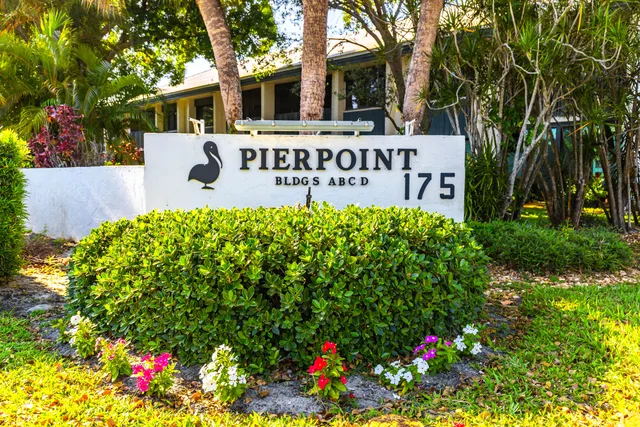 a view of a sign board with flower in front of house