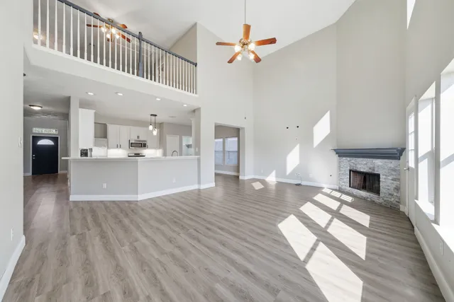 a view of a living room and kitchen with furniture wooden floor windows