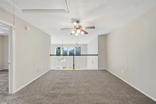a view of a livingroom with a ceiling fan & window