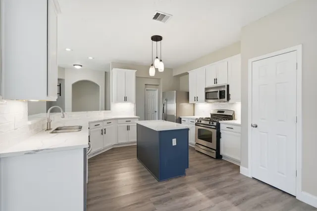 a kitchen with a sink stove and refrigerator