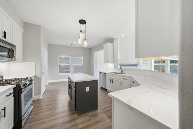 a kitchen with a stove a sink and a refrigerator