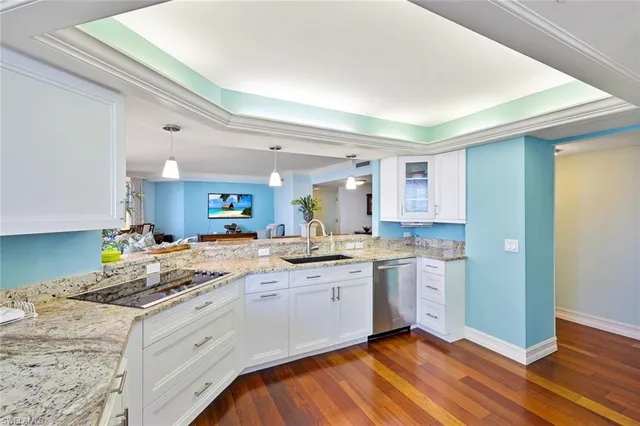 a kitchen with a sink cabinets and wooden floor