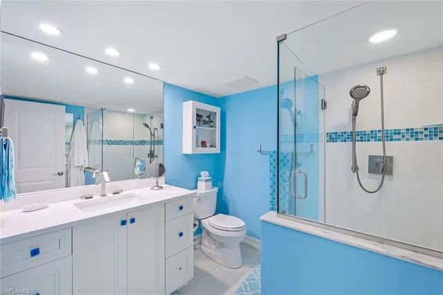 a bathroom with a double vanity sink toilet mirror and shower