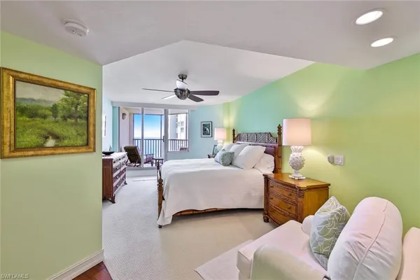 a spacious bedroom with a bed and a chandelier