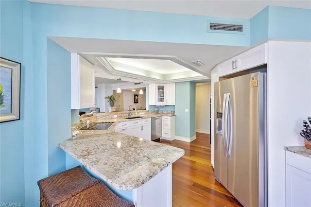 a large kitchen with a lot of counter space and wooden floor