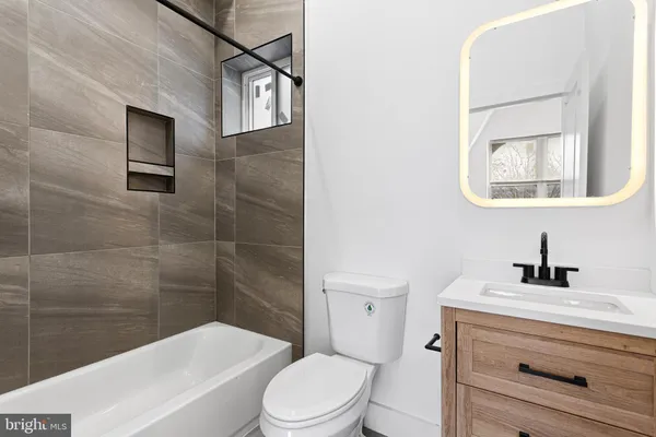 a bathroom with a toilet a sink a mirror and bathtub