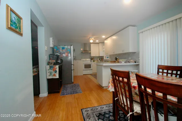 a kitchen with stainless steel appliances kitchen island granite countertop a dining table and chairs